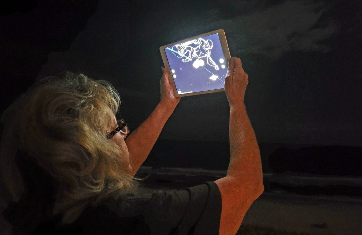 Woman studies the screen on her mobile device learning science.